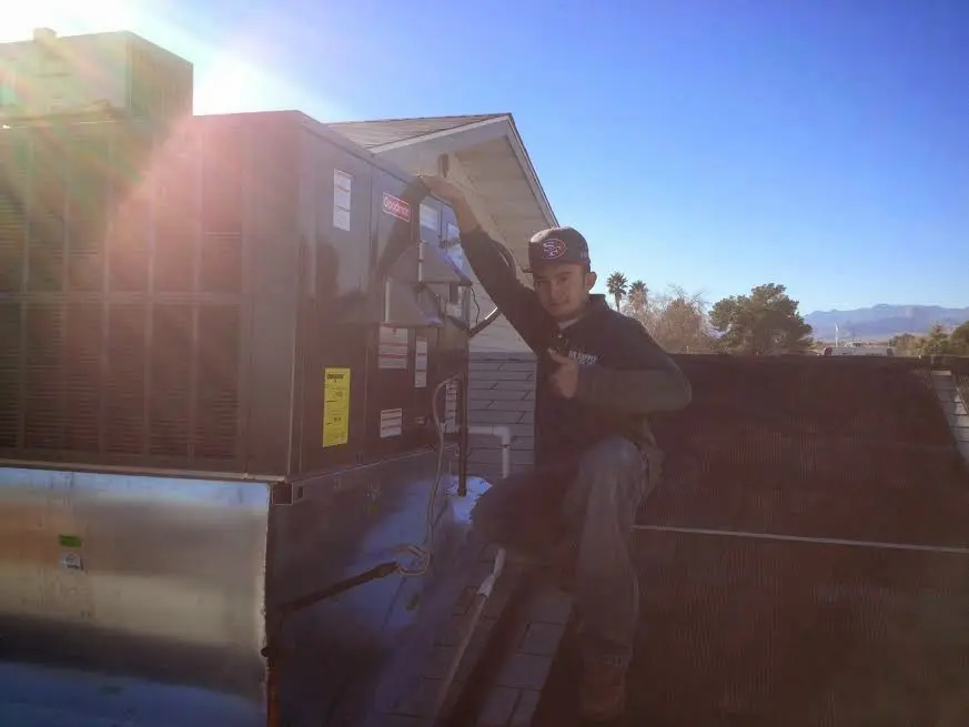 HVAC technician performing HVAC Inspection on a rooftop unit in Reston